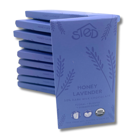A stack of chocolate bars labeled Honey Lavender, 50% organic milk chocolate, with USDA organic seal and notes indicating soy free, gluten free, and palm oil free.