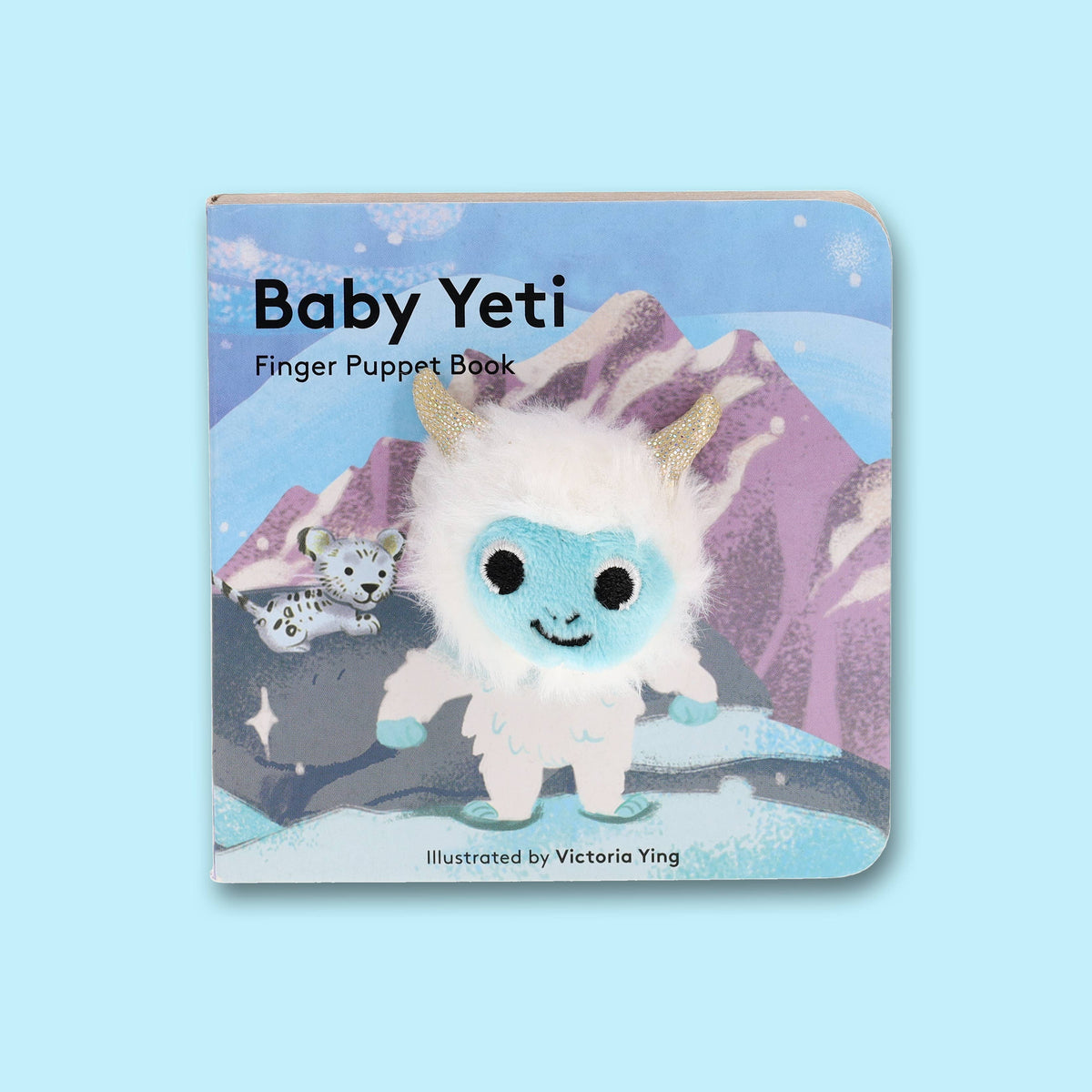 Board book with a plush baby yeti finger puppet attached to the cover, featuring an illustration of a snow leopard in a mountain landscape.