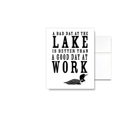 The A Bad Day at the Lake is Better than a Good Day at Work Card features linen texture, lake-inspired text, and a loon illustration—perfect for lakehouse stationery fans and as a thoughtful greeting card.