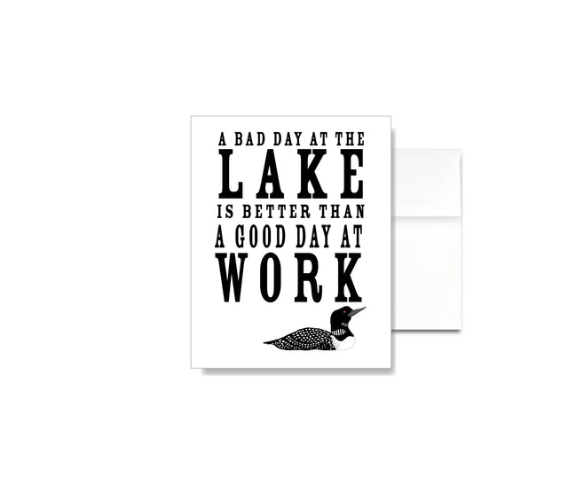 The A Bad Day at the Lake is Better than a Good Day at Work Card features linen texture, lake-inspired text, and a loon illustration—perfect for lakehouse stationery fans and as a thoughtful greeting card.