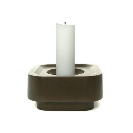 A white candle stands upright in the Stumpastaken Ettan candle holder, made from 100% recycled material with a white powdercoated finish (8.8x8.8x4 cm), on a plain white background.