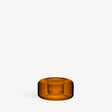 Low-profile amber blown glass votive candle holder with a rounded, circular shape.