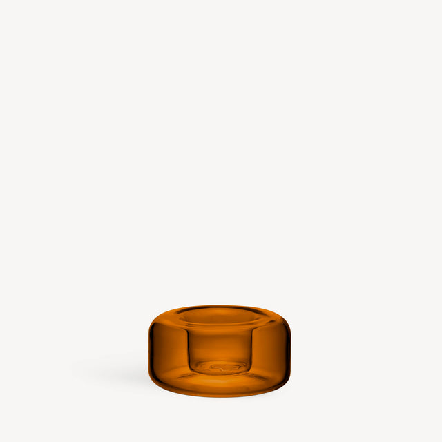 Low-profile amber blown glass votive candle holder with a rounded, circular shape.