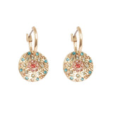 Earrings: A&C Oslo Vibrance Gold Coin Earrings feature round, textured gold-toned layered pendants with small blue, turquoise, and pink gemstones in a circular pattern for a vibrant, colorful look.