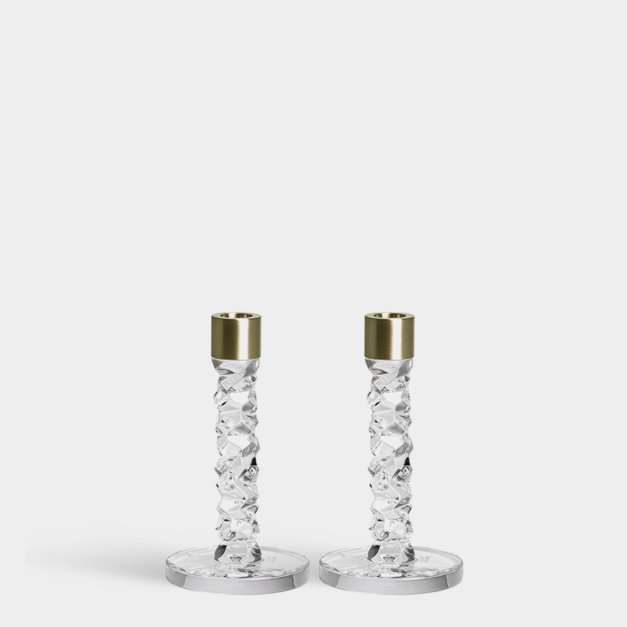 The Orrefors: Carat Candlestick Brass (2-Pack) features two elegant crystal glass candlesticks with gleaming brass tops on a plain background, showcasing timeless design.