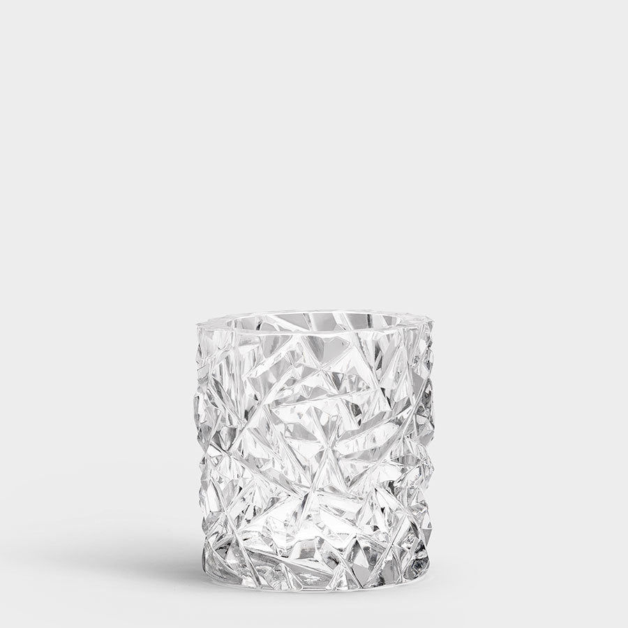 The Orrefors Carat Candle Holder Small, a clear crystal glass featuring a textured geometric pattern, stands elegantly against a plain white background.