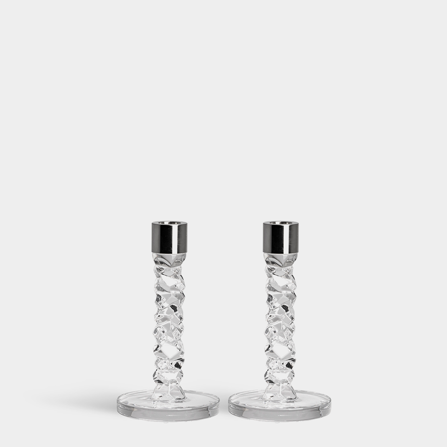 Two Orrefors Carat candlesticks with silver tops and a twisted design sit against a plain white background.