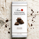 Nói Síríus chocolate bar wrapper with pieces of 56% dark chocolate on a wooden surface; visible text includes “3.53 oz (100g)”.