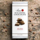 Sirius chocolate bar labeled 33% cocoa on a wooden surface with several pieces of broken Icelandic milk chocolate around it.