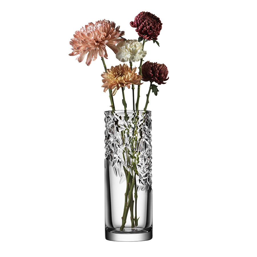 An Orrefors Carat Vase Upper Cut holds five assorted chrysanthemums in shades of pink, burgundy, and white on long stems.