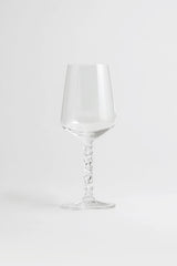 A pair of Orrefors Carat Wine Glasses (14.8oz) with textured stems stand elegantly on a white surface, highlighting their crystal clarity against a plain light background.