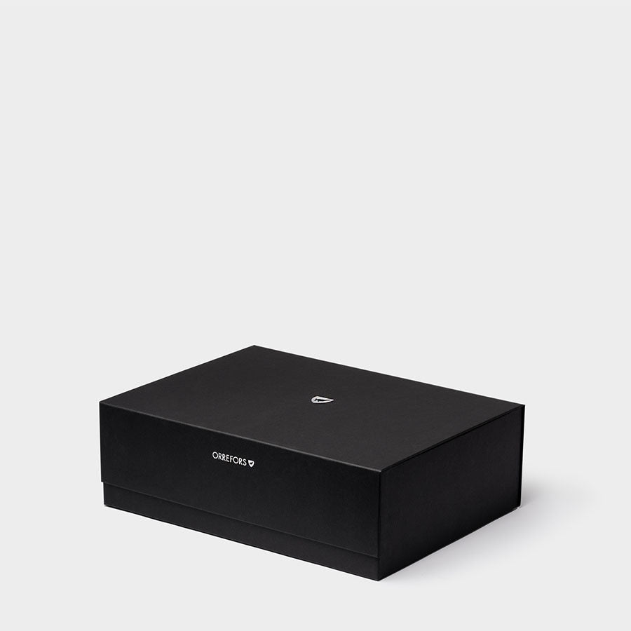 The Orrefors Carat Bowl & Vase Bundle, set against a plain white backdrop, is housed in a black rectangular box with subtle white text and a small logo, offering an aura of elegance reminiscent of Crystal Geometry designs.