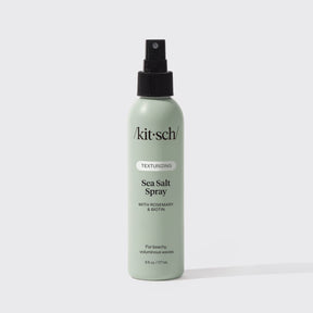 A green 6 fl oz bottle of KITSCH Spray: Texturizing Sea Salt Hair Spray with Rosemary & Biotin is displayed against a plain white background. This vegan hair product features clean ingredients and serves as both a volumizing spray and texturizer, making it ideal for creating effortless, beachy waves.