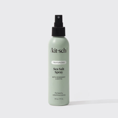 A green 6 fl oz bottle of KITSCH Spray: Texturizing Sea Salt Hair Spray with Rosemary & Biotin is displayed against a plain white background. This vegan hair product features clean ingredients and serves as both a volumizing spray and texturizer, making it ideal for creating effortless, beachy waves.