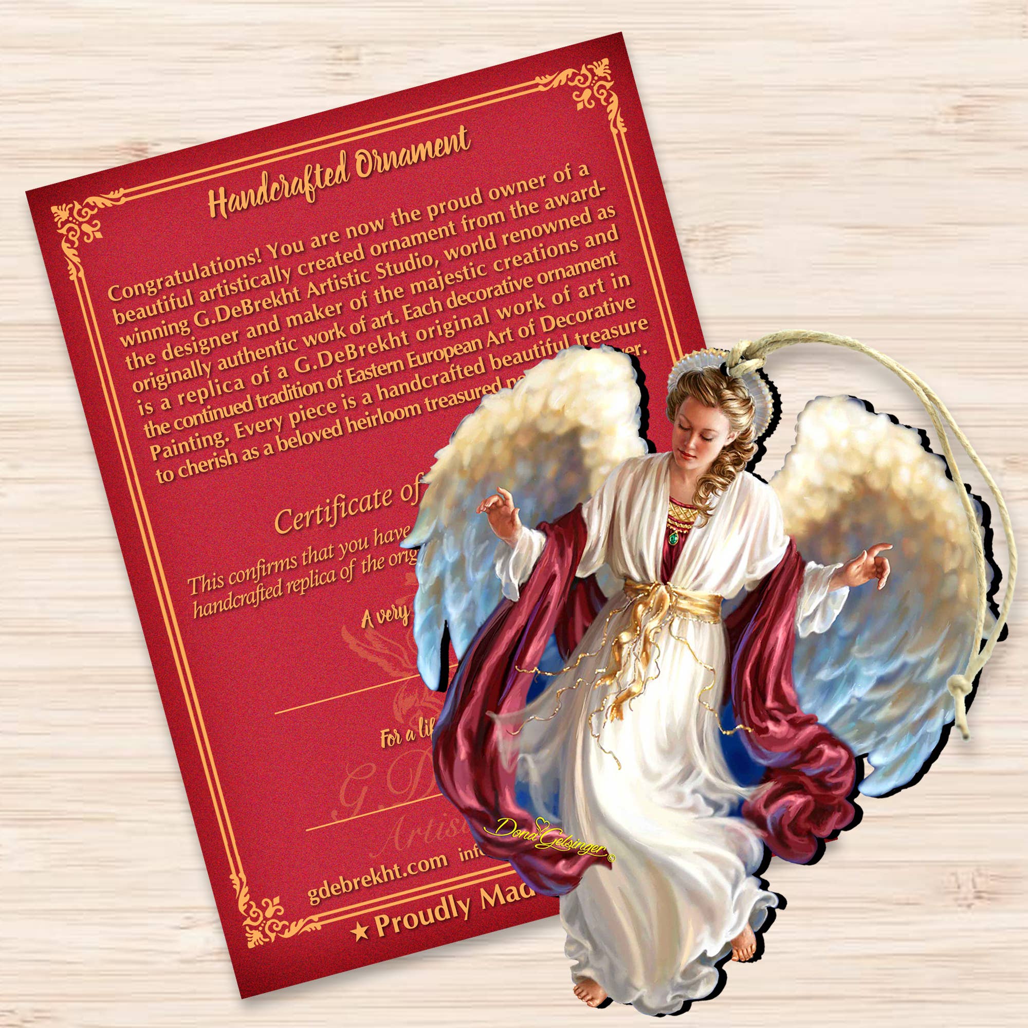 Partially covering the certificate with a red border and gold text is the "Peace on Earth Angel" wood ornament by Dona Gelsinger, featuring a handcrafted angel figurine in a white and red robe with wings and a halo, ideal for adding charm to your holiday gallery.