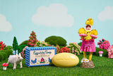 A child in a chick costume stands by a bar and gift box of Eggwhite & Chamomile Facial Soap, with a toy goat and vibrant decor, showcasing this hydrating cleanser in its 1.76 oz gingham box.