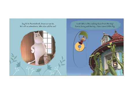 An illustrated spread from "Book: Meet the Moomins! Moomin Valley A Push, Pull, and Slide Book" shows Moomintroll inside a house on the left and Little My descending by umbrella near a tower and tall plants on the right.