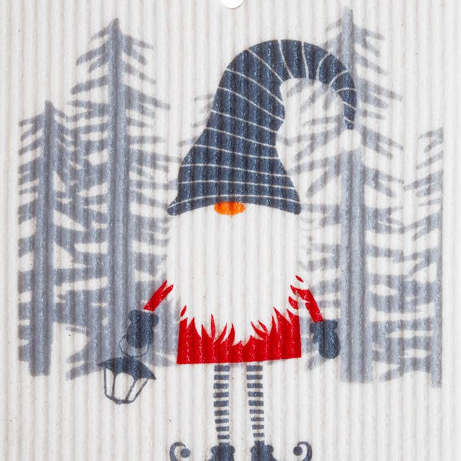 Swedish dish cloth featuring a gnome with a pointy hat, holding a lantern in front of stylized trees.