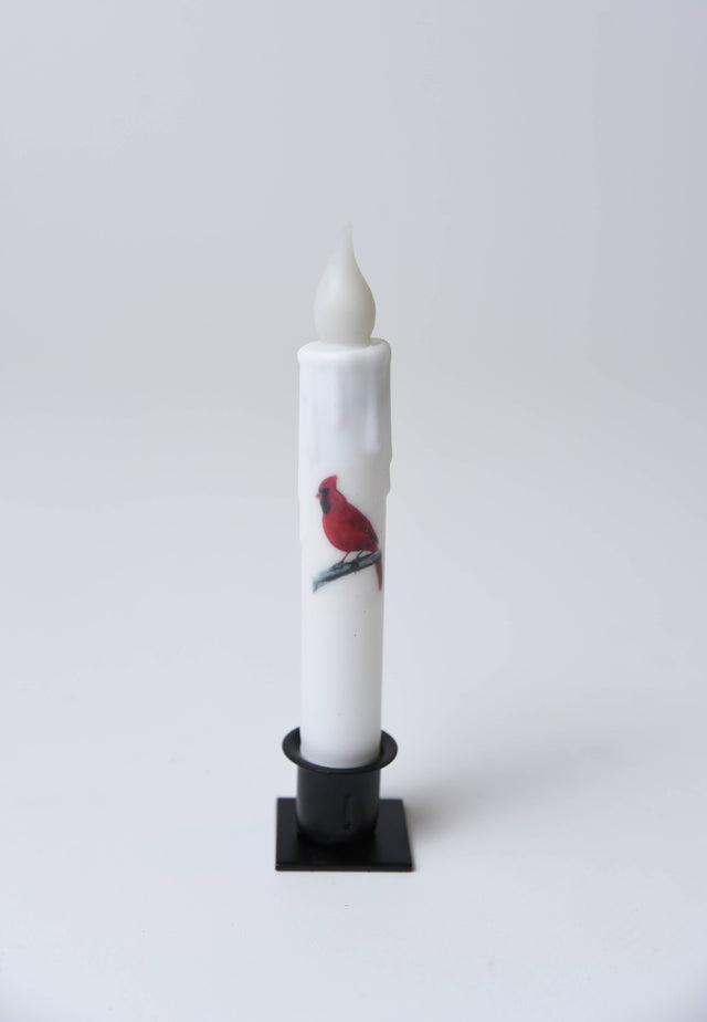 The Candle: Cardinal LED Timer Taper Candle, White 7", features a faux flame in a black holder with a red cardinal perched on a branch illustration.