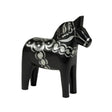 The Dala Horse: Celebrate Black & Silver, a hand-crafted black wooden figure adorned with intricate silver patterns, stands gracefully against a pristine white background, embodying Swedens traditional artistry.