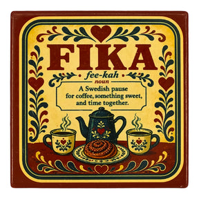 Square coaster featuring the word FIKA, a definition, a coffee pot, mugs, and a cinnamon bun, all decorated in traditional Swedish-style floral motifs.