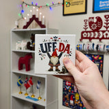 A square Scandinavian-style ceramic coaster featuring a red-hatted gnome, an overturned mug, and the text UFF DA.
