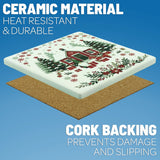 Square Nordic ceramic coaster featuring a red cabin, evergreen trees, and poinsettia illustrations, with a cork backing.