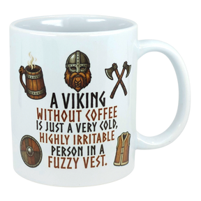 Ceramic mug with Nordic Viking art, featuring an axe and helmet illustration, and the text: “A Viking without coffee is just a cold, irritable person in a fuzzy vest.”.