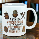 White ceramic mug with Nordic-themed cartoon Viking and printed text: “A Viking without coffee is just a very cold, highly irritable person in a fuzzy vest.”.