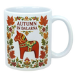 White ceramic mug featuring leaves, flowers, a red Swedish Dala horse, and the text “AUTUMN IN DALARNA” in Scandinavian folk art style.