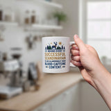 In a kitchen, a hand holds the Swedish Gift Store's 11 oz "Behind Every Successful Scandinavian Ceramic Mug," featuring the witty quote and playful designs of trees, a moose, house, and sun on its white surface.