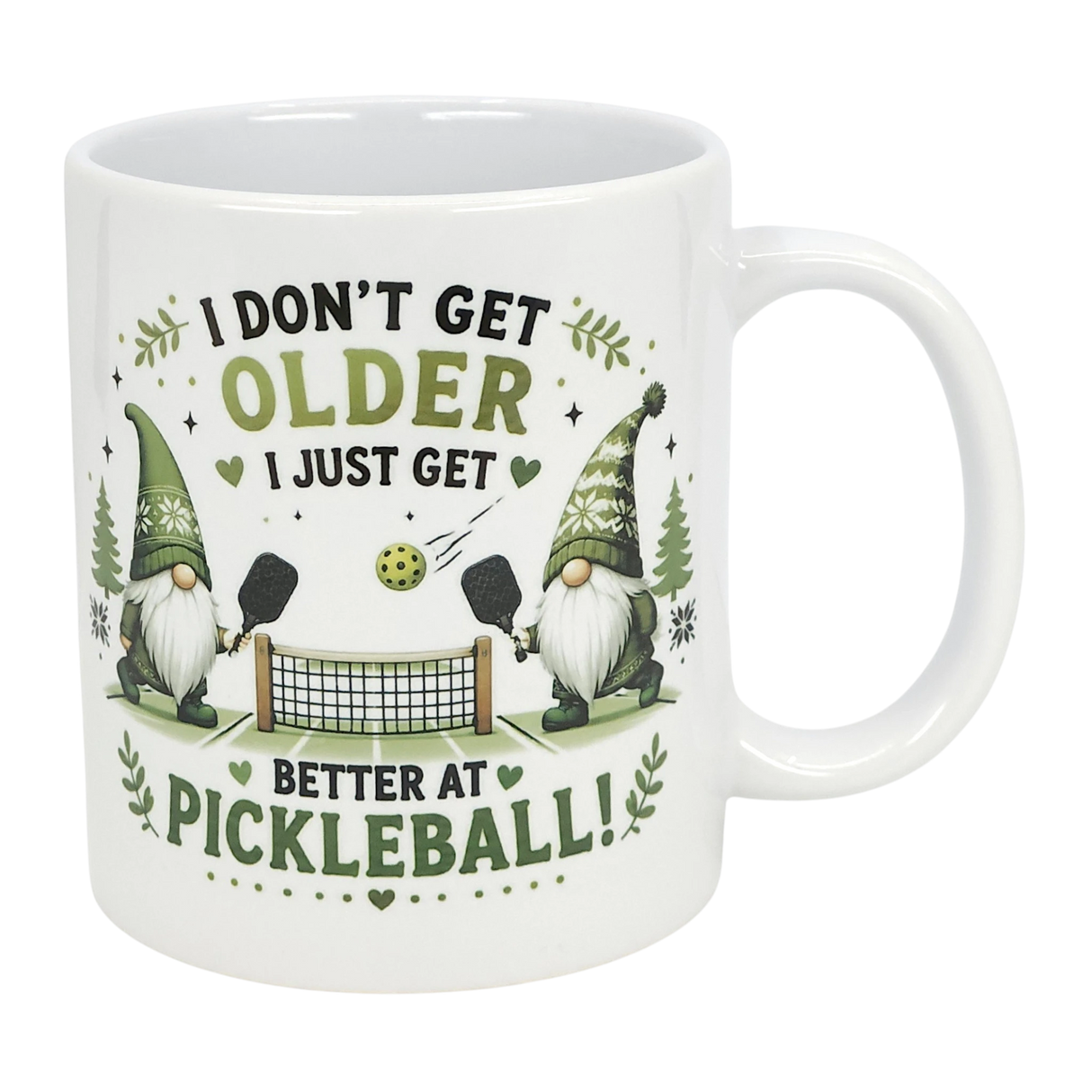 The Nordic Wholesale "Better at Pickleball" Ceramic Gnome Mug (11 oz) features two Nordic gnomes with paddles, net, and ball, green accents, and fun text: "I don't get older, I just get better at pickleball!" A perfect gift for pickleball fans.