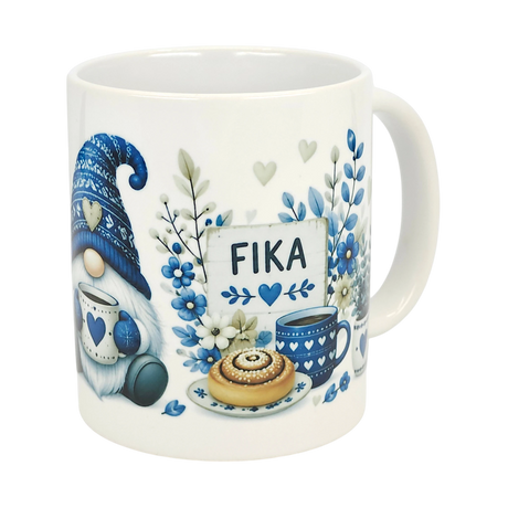 The Nordic Wholesale Mug: Blue Tomte Gnome Fika Ceramic Mug (11 oz) features a blue-and-white Scandinavian gnome with a heart mug, teacup, pastry, flowers, and FIKA sign—all in cozy Swedish coffee cup style.