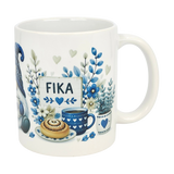 The Nordic Wholesale Mug: Blue Tomte Gnome Fika Ceramic Mug (11 oz) features blue and gray Scandinavian Tomte gnome designs with flowers, a cinnamon roll, coffee cup, and a “FIKA” sign surrounded by hearts and leaves.