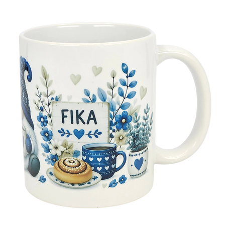 The Nordic Wholesale Mug: Blue Tomte Gnome Fika Ceramic Mug (11 oz) features blue and gray Scandinavian Tomte gnome designs with flowers, a cinnamon roll, coffee cup, and a “FIKA” sign surrounded by hearts and leaves.