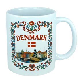 Celebrate Danish heritage with the Nordic Wholesale Mug: Denmark Nyhavn Ceramic Mug (11 oz Capacity), featuring vibrant floral patterns, “DENMARK” in bold red lettering, the Danish flag, a detailed illustration of the Little Mermaid statue, and a charming cityscape inspired by Nyhavn harbor—an ideal addition to your collection.
