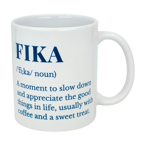 The Swedish Gift Store's White Ceramic Fika Definition Mug (11 oz) features blue text defining "FIKA"—a moment to slow down and savor the good things in life, often with coffee and a treat. Perfect for relaxing Swedish-style coffee breaks.