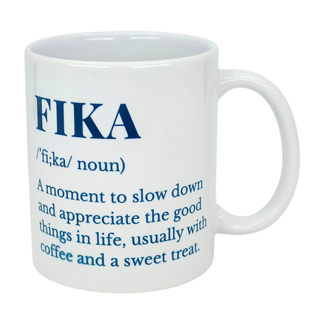 The Nordic Wholesale Mug: White Ceramic Fika Definition Mug (11 oz) features the word FIKA, its pronunciation, and definition—a Swedish coffee mug perfect for relaxing and enjoying a slow moment with your favorite brew.