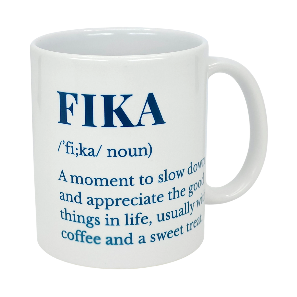 The Swedish Gift Store's White Ceramic Fika Definition Mug (11 oz) features blue text defining FIKA as a noun—a moment to slow down and savor the good things, often enjoyed with coffee and a sweet treat.