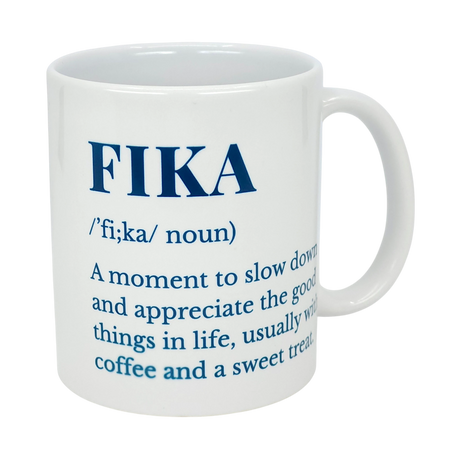 The Mug: White Ceramic Fika Definition Mug (11 oz) by Nordic Wholesale features blue text defining FIKA—a noun for pausing to enjoy life’s good moments, often with coffee and a treat. Perfect for your daily Swedish-style coffee break.