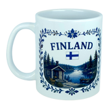 Discover the Nordic Wholesale Mug: Finland Lakeside Cabin Ceramic Mug (11 oz Capacity), featuring the word "Finland," the Finnish flag, and a scenic illustration of a Nordic lakeside cabin surrounded by trees, bordered with blue floral designs—a perfect Finnish heritage gift.