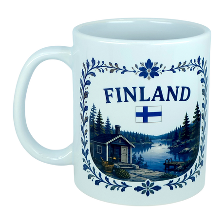 Discover the Nordic Wholesale Mug: Finland Lakeside Cabin Ceramic Mug (11 oz Capacity), featuring the word "Finland," the Finnish flag, and a scenic illustration of a Nordic lakeside cabin surrounded by trees, bordered with blue floral designs—a perfect Finnish heritage gift.