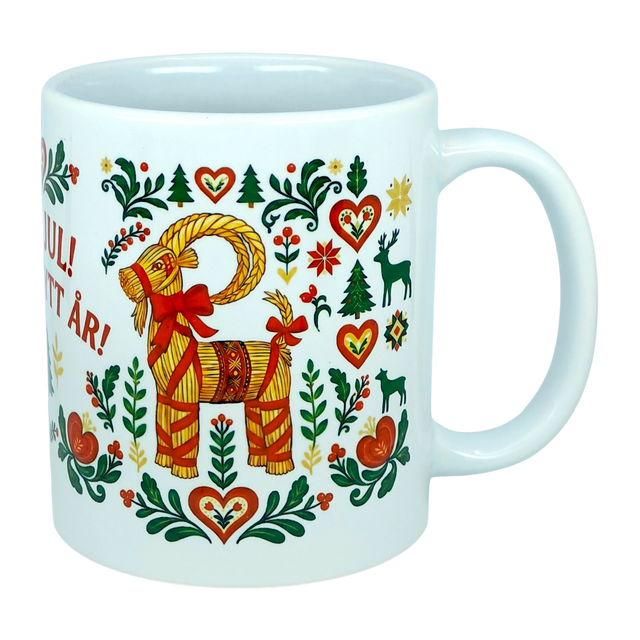 This white 11 oz ceramic mug from Nordic Wholesale features the God Jul Gott Nytt År Yule Goat design, beautifully decorated with colorful Scandinavian folk art motifs including hearts, trees, flowers, and animals in vibrant red, green, and yellow. Charming Nordic details and partially visible Swedish text complement this festive holiday mug.