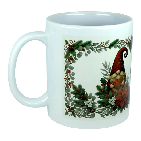 The God Jul Tomte Nordic Christmas Ceramic Mug by Nordic Wholesale features a festive Scandinavian design with a gnome in a red hat, surrounded by greenery, pinecones, berries, and white flowers within a decorative border.