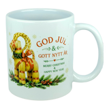 The Nordic Wholesale Mug: God Jul Yule Goat Ceramic Mug (11 oz Capacity) is a white mug decorated with a traditional Swedish Julbock—the straw Scandinavian Yule Goat—embellished with red ribbons and festive greenery. The mug features the greeting "God Jul & Gott Nytt År" in Swedish and its English translation, "Merry Christmas & Happy New Year.