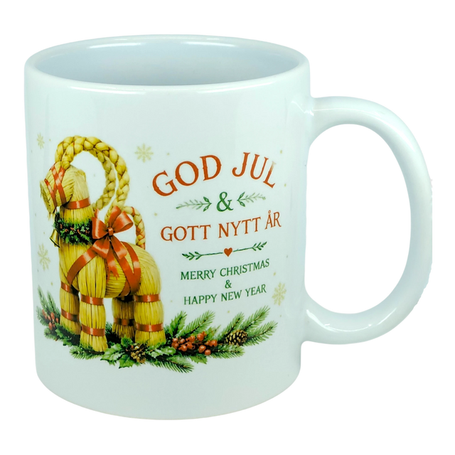 The Nordic Wholesale Mug: God Jul Yule Goat Ceramic Mug (11 oz Capacity) is a white mug decorated with a traditional Swedish Julbock—the straw Scandinavian Yule Goat—embellished with red ribbons and festive greenery. The mug features the greeting "God Jul & Gott Nytt År" in Swedish and its English translation, "Merry Christmas & Happy New Year.