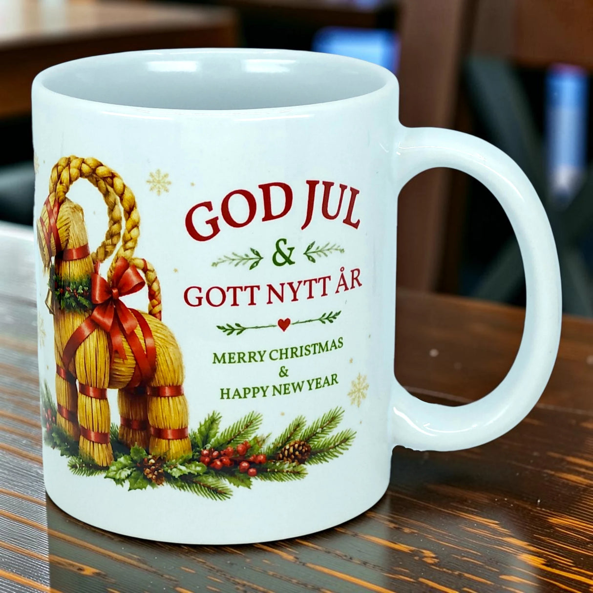 A white 11 oz ceramic mug from Nordic Wholesale, the "Mug: God Jul Yule Goat Ceramic Mug," is adorned with festive decorations and traditional Scandinavian motifs, including Swedish text "God Jul & Gott Nytt År" and the English greeting "Merry Christmas & Happy New Year." Featuring a classic Julbock (Yule Goat) design, this charming mug is perfect for celebrating the season in true Swedish style.