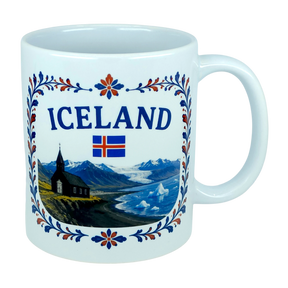 Introducing the Mug: Iceland Church Mountain Ceramic Mug (11 oz Capacity) by Nordic Wholesale. This white ceramic mug features "ICELAND," the Icelandic flag, and a picturesque scene of mountains, a church, water, and icebergs. A decorative blue and red floral border frames the Nordic landscape, making this mug an ideal gift for anyone celebrating their Icelandic heritage.