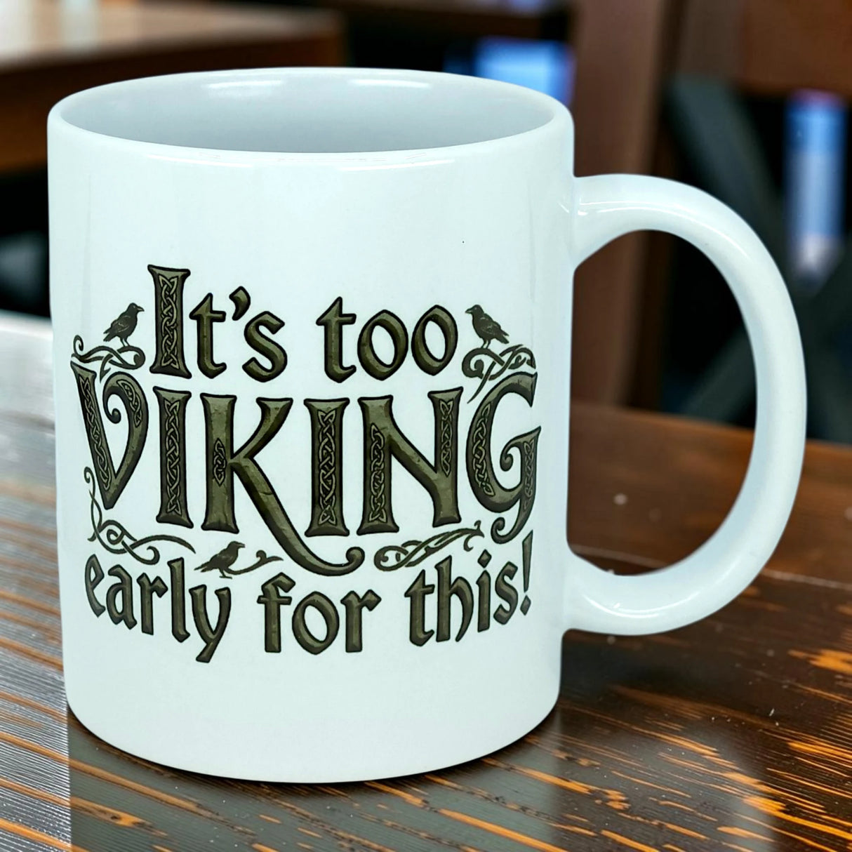 A white 11 oz ceramic mug from Nordic Wholesale sits on a wooden table, showcasing the playful phrase "It's Too Viking Early For This"—a perfect blend of Norse humor to kick off your morning routine.