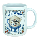 Introducing the Nordic Wholesale Mug: Lindstrom America's Little Sweden Ceramic Coffee Mug (11 oz)—featuring a charming decorative design with a water tower labeled "Välkommen till Lindström," surrounded by floral motifs inspired by Scandinavian folk art and the phrase "Lindstrom, America’s Little Sweden." A perfect mug for celebrating your Swedish heritage.